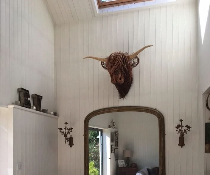 Décoration murale rustique en forme de tête de vache pour une maison unique.