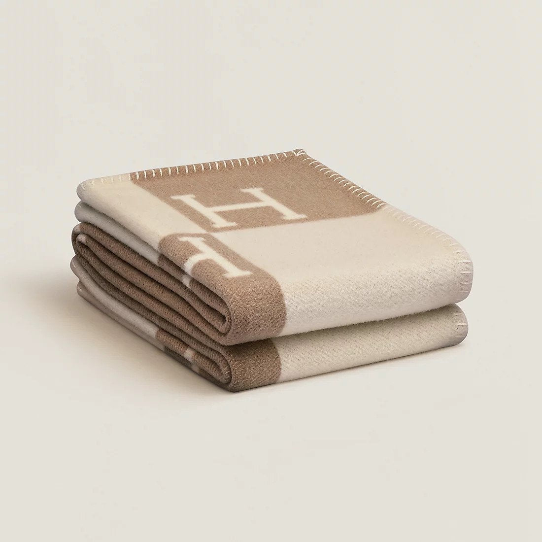 Plaid en laine et cachemire beige sur un lit