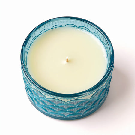 Bougie parfumée Ocean Mist en cire de soja dans un pot en verre bleu avec motif de vagues